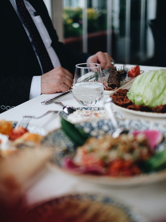 Close-up of a formal dining table with elegantly presented meals and glassware in a restaurant.